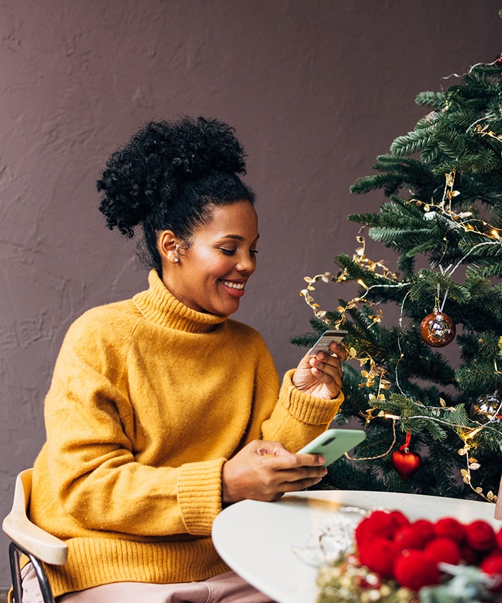 Woman looking at her phone to learn more about holiday scams.