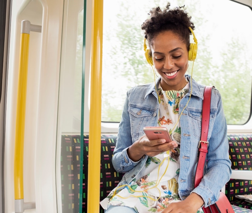 A woman watches reality TV and learns about location tracking on her smart phone while riding the metro.