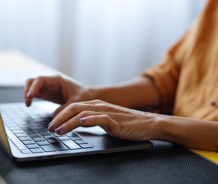 Photo of someone typing on a laptop.