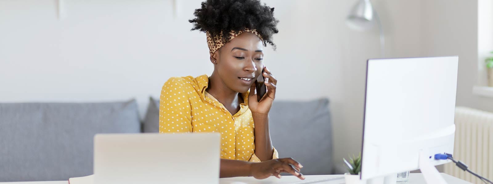 A woman answers a phone call at her desk after learning about caller ID spoofing.