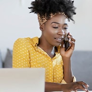 A woman answers a phone call at her desk after learning about caller ID spoofing.