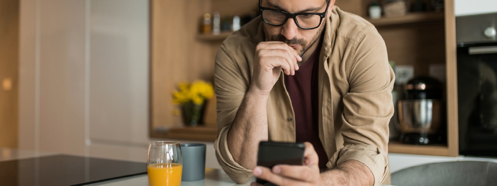 A man looking at his phone learning about clone phishing.