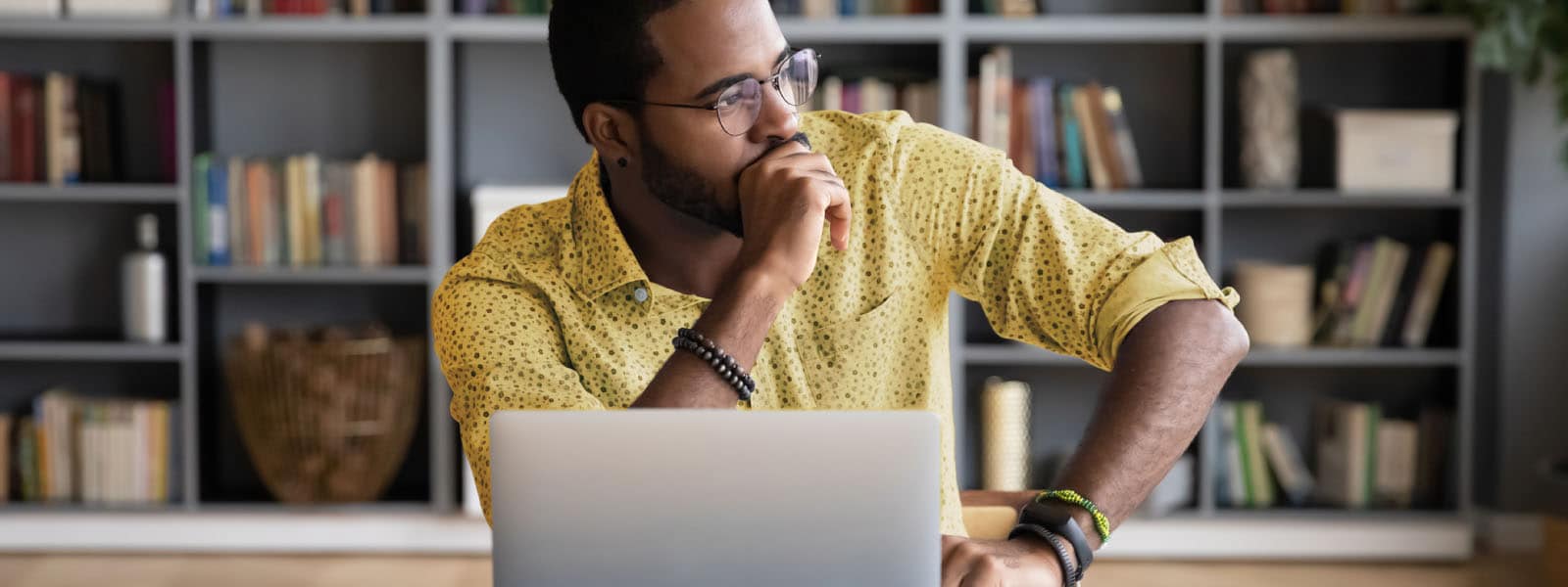 A man contemplates cloud security risks while using his laptop. 