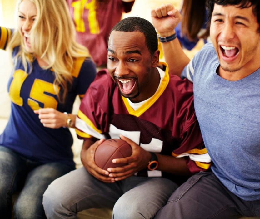 Football fans cheer as they watch their team, knowing they’re safer from cyber threats during football season.