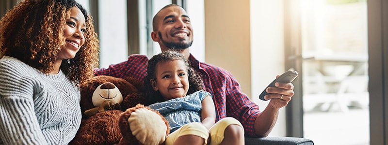 A family watching their smart TV, but aware of the potential privacy risks associated with it.