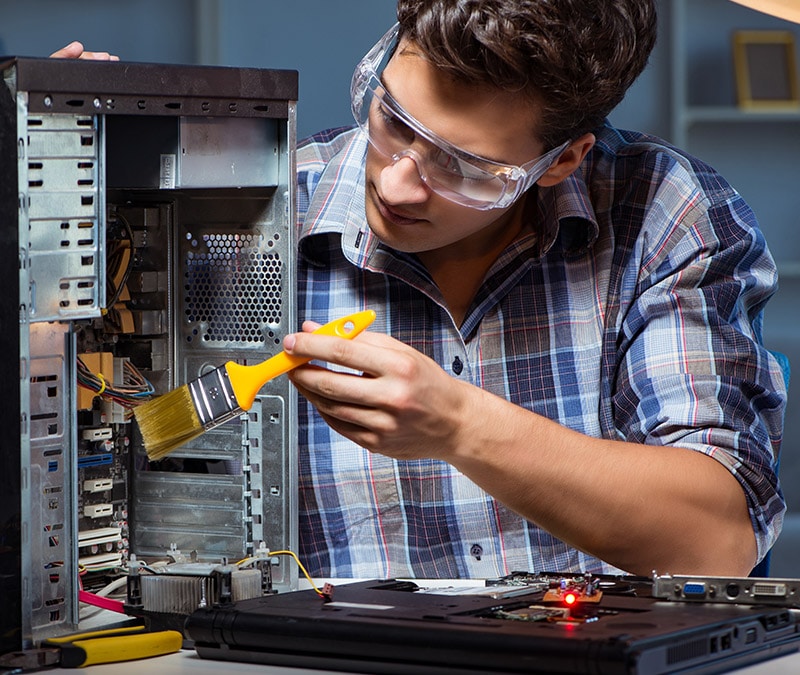 An illustrative image of a man cleaning the internal components of his PC.