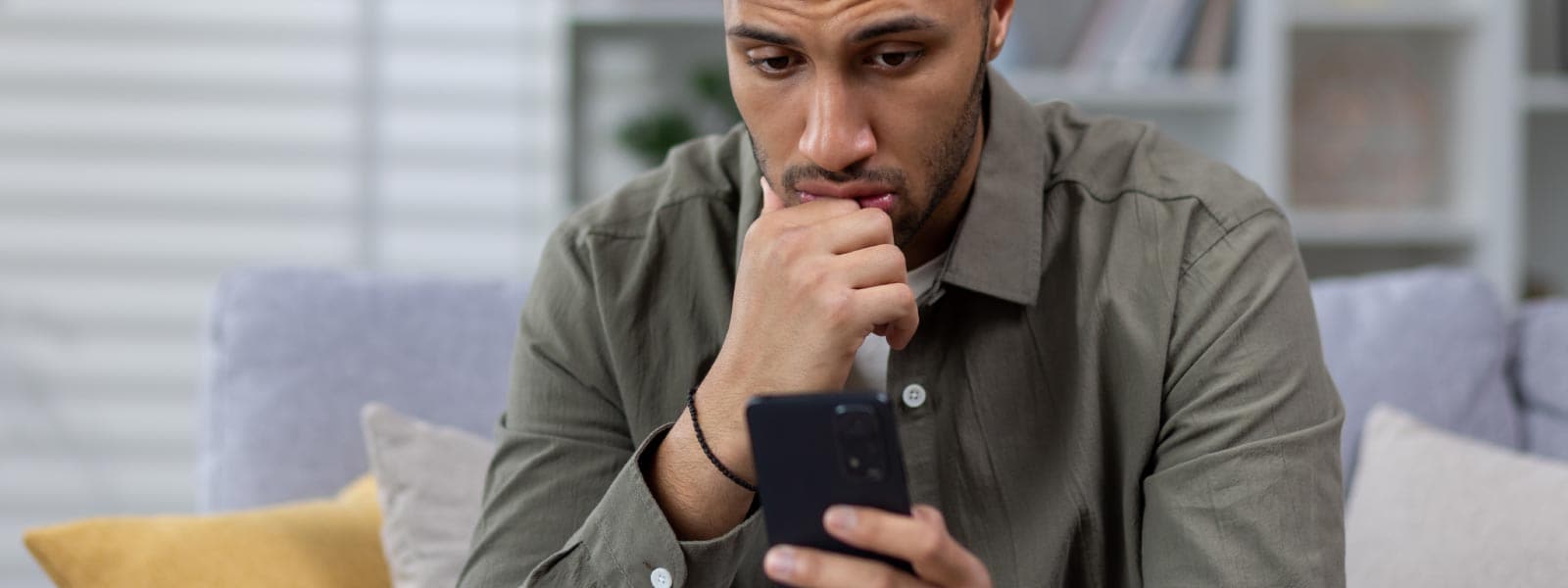 Person looking at a phone figuring out how to tell if their phone is tapped.