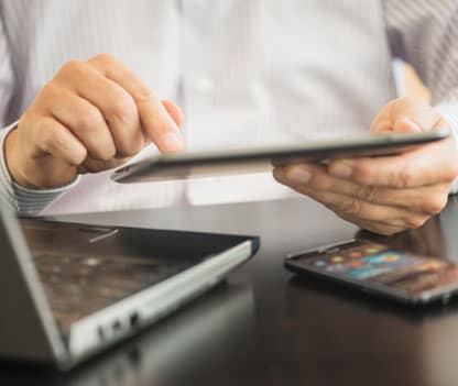 A man holding a tablet and researching email spoofing.