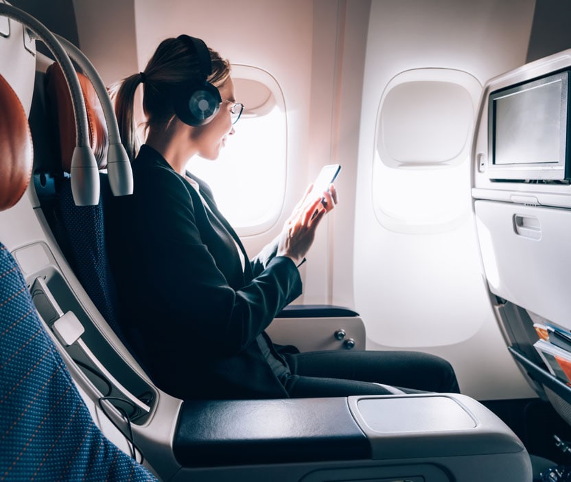 Woman on plane researching safety of 4G vs Wi-fi.