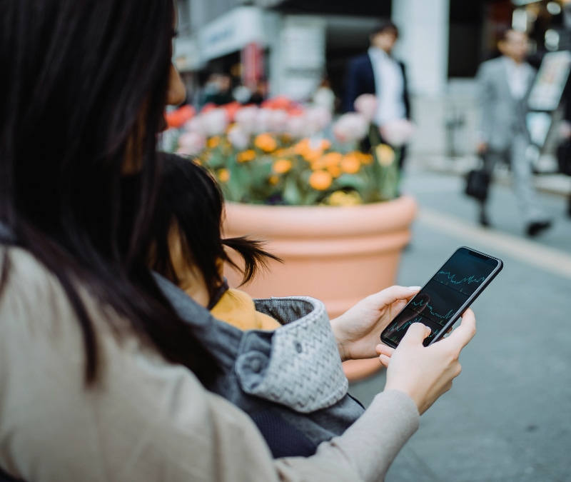 A woman checking her P2P app before sending money.