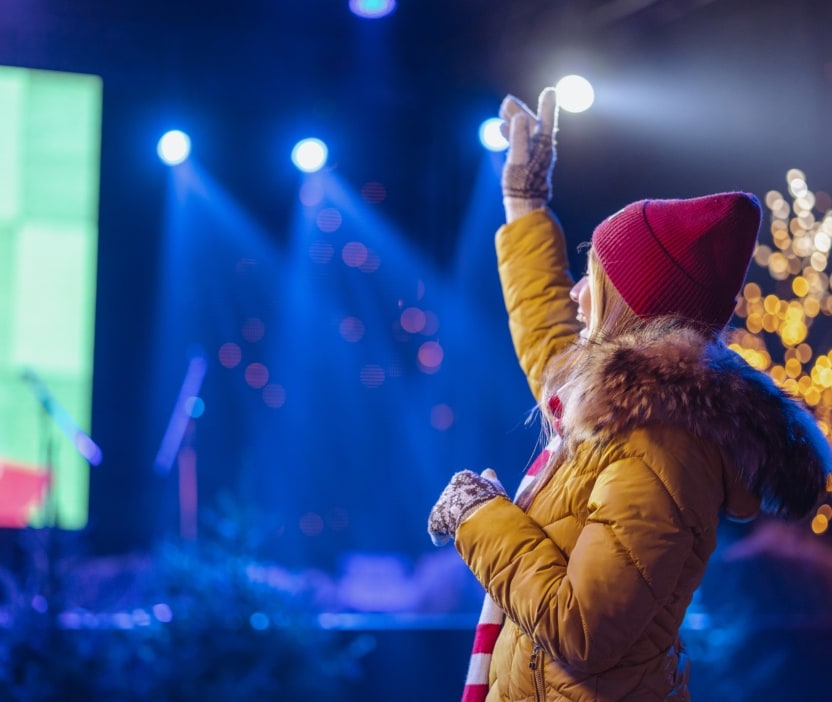 A young woman enjoys a concert after avoiding scams when she was buying a ticket.