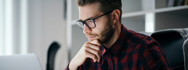 Man researching proxy versus VPN on his computer.