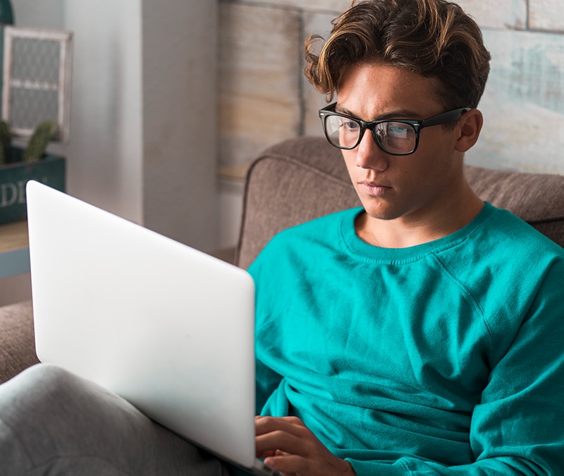 A man uses his laptop to research what a script kiddie is.