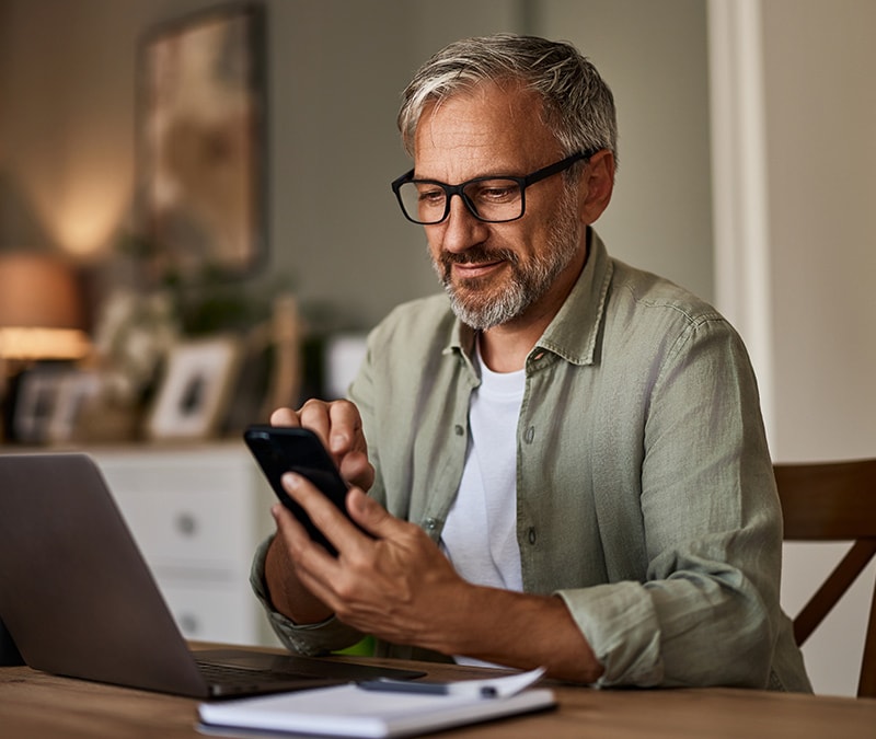 A man looking up what is smishing on his smartphone. 