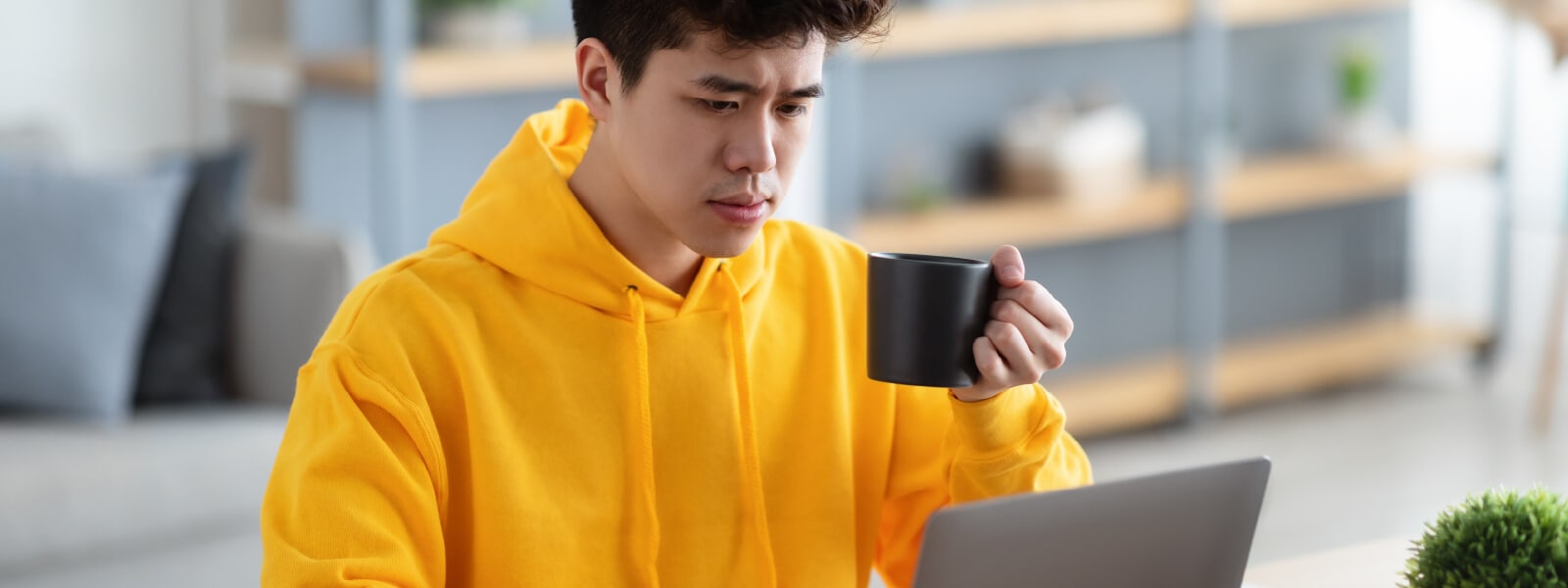 A man looking at his computer wondering if his device has spyware.