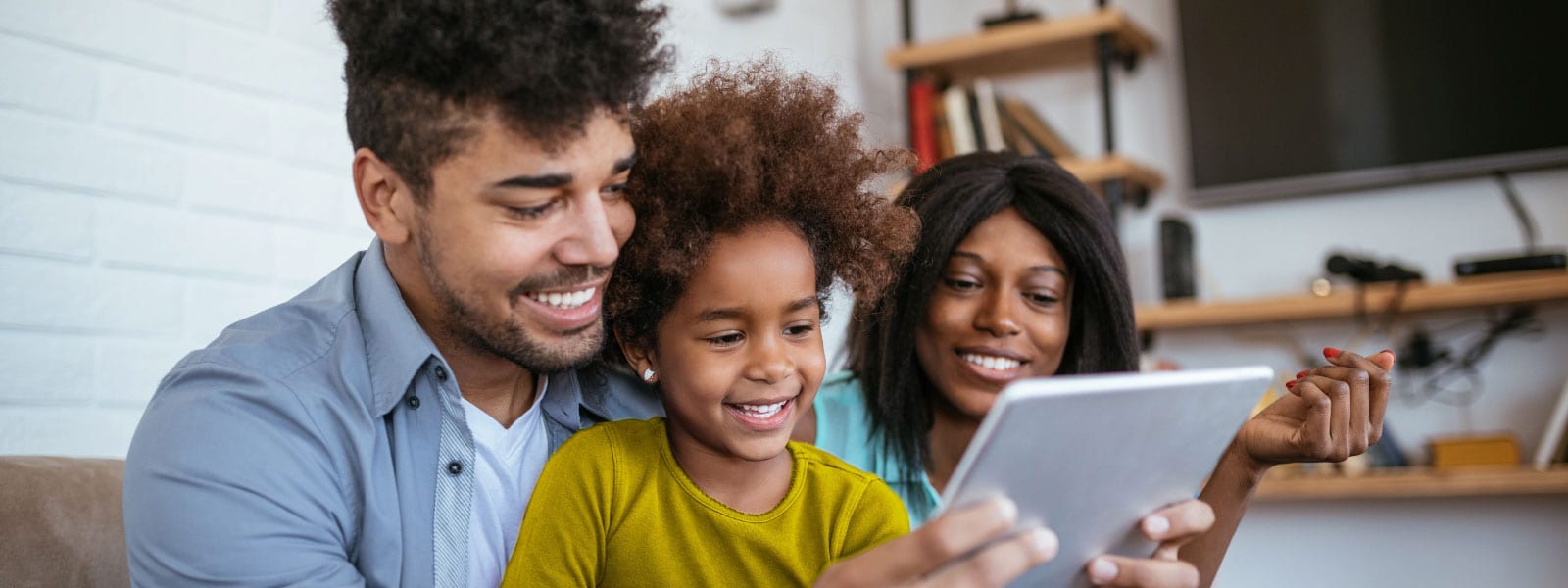 A family looking at a tablet learning about internet safety for kids.