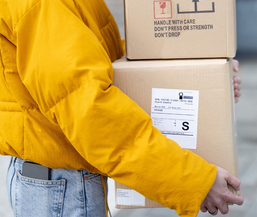 A woman carries boxes into a secure location, which could be targeted in a tailgating attack