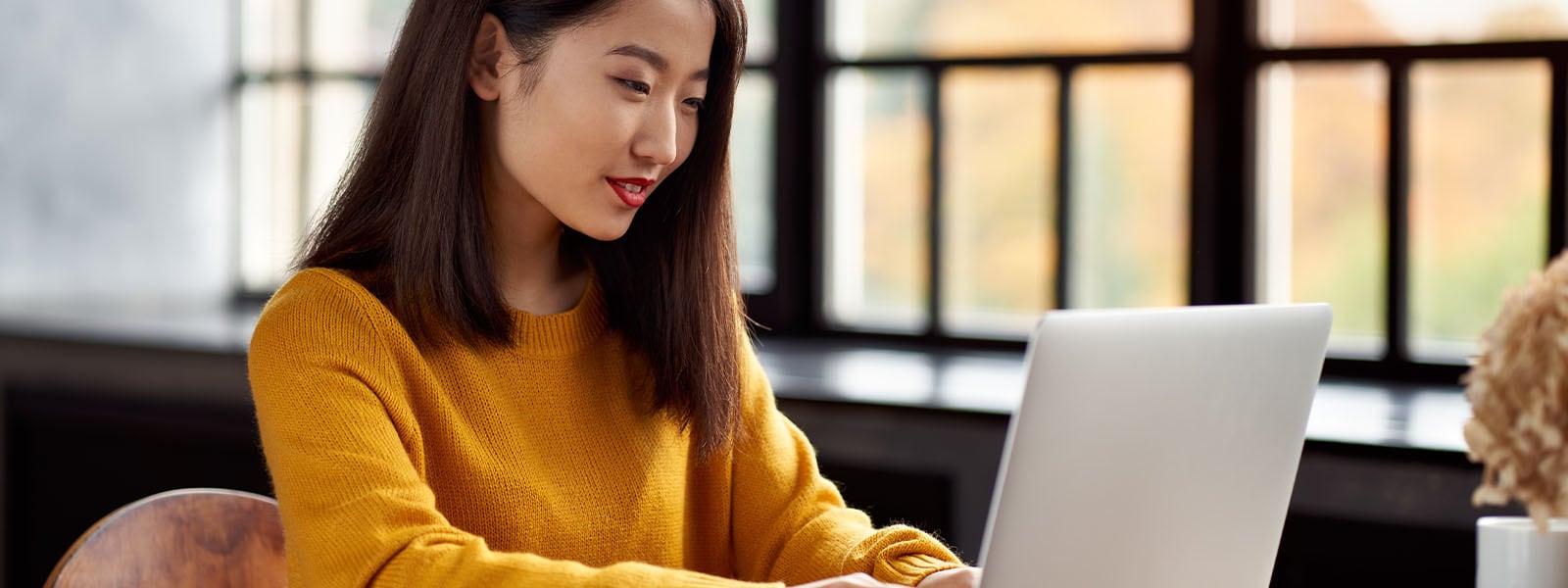  A woman uses her laptop to research the different types of identity theft.