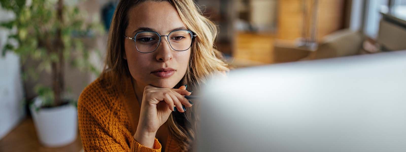 A woman looks at her computer screen and considers her options after a hacker targets her in a ransomware attack. 