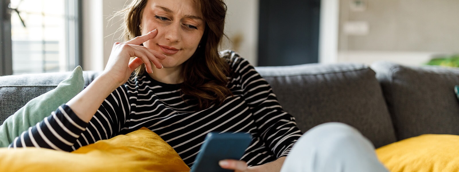 A woman takes a closer look at a possible vishing scam on her phone. 