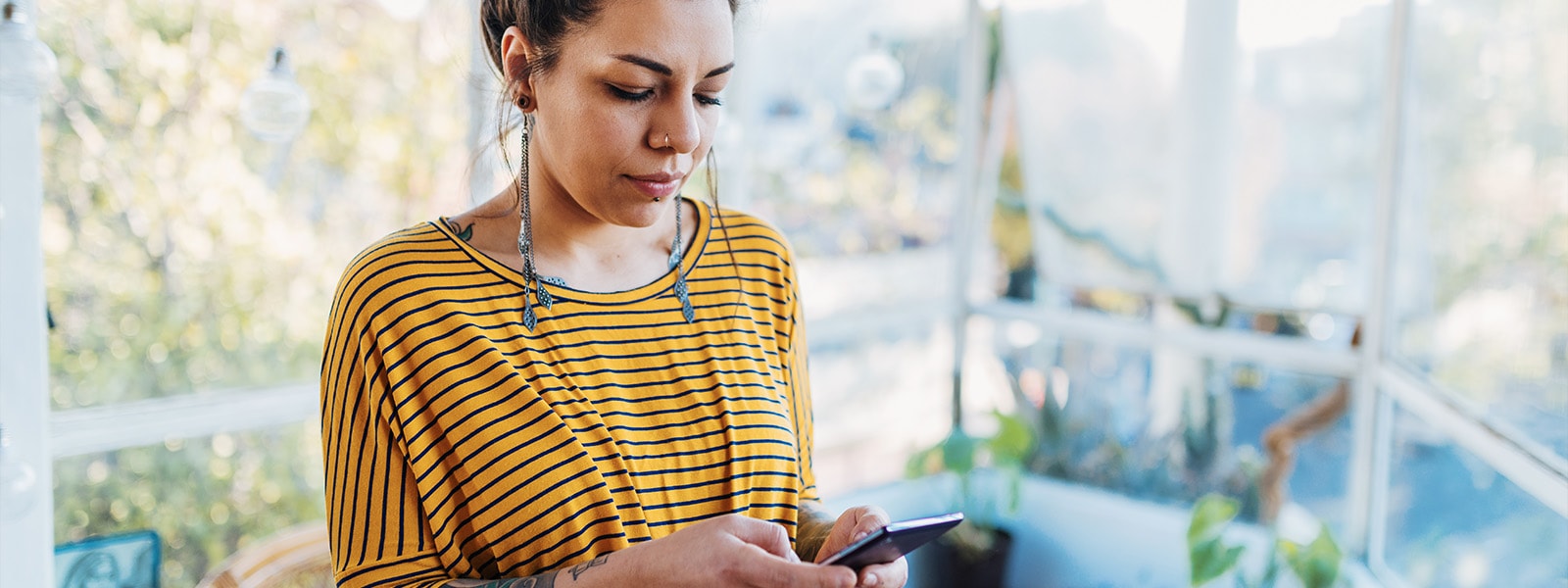 A woman uses her smartphone to answer the question, “What is a chatbot?