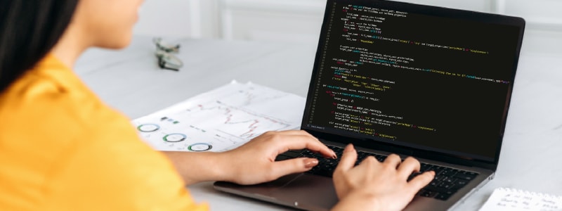 A woman uses her computer after learning the answer to the question, "What is a computer driver?"