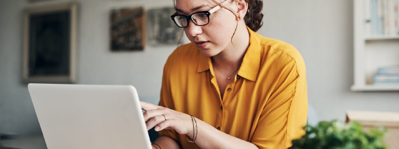 Woman looking at laptop learning about watering hole attacks.