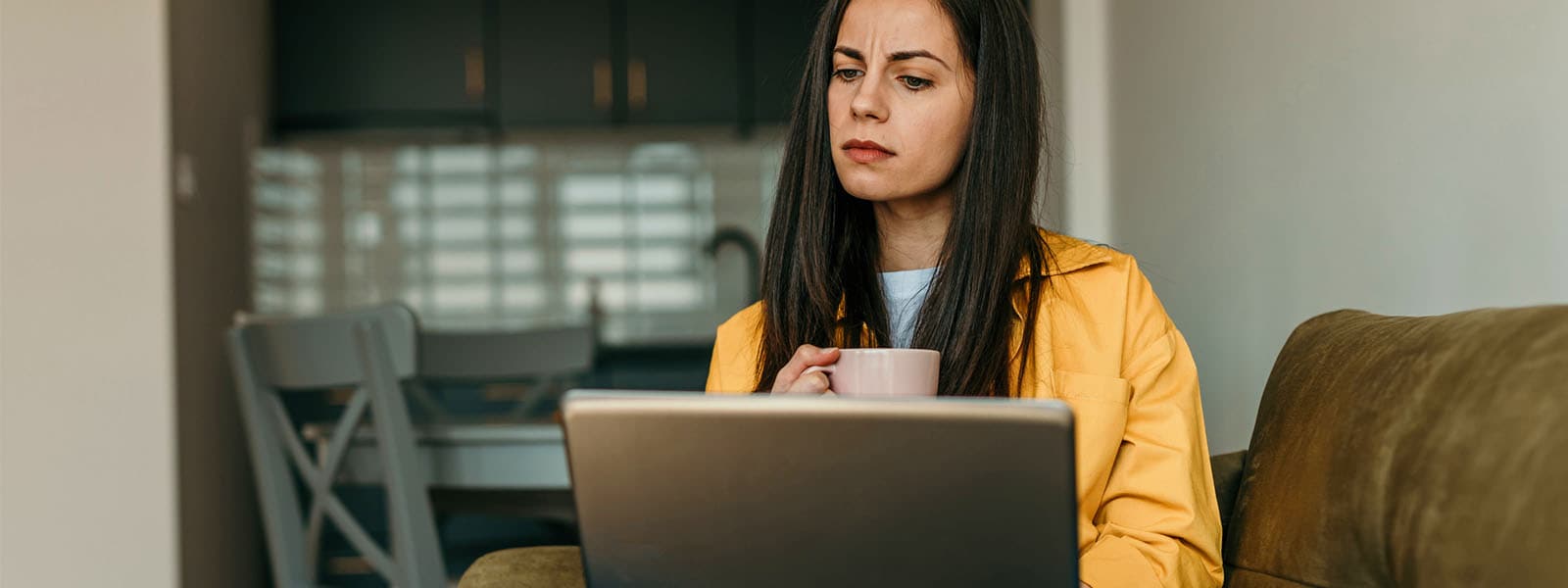 Woman looking at her computer learning about cyberstalking.