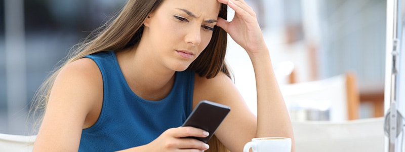 A woman frustrated with a virus on her Android phone, learning how to remove it.