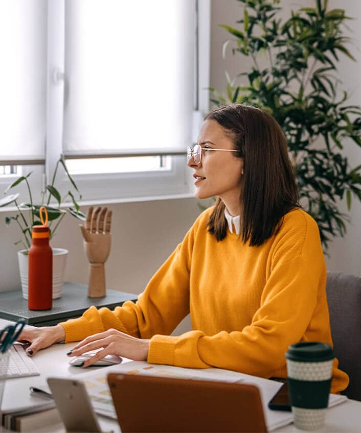 A woman reads about a zero-day exploit on her computer.