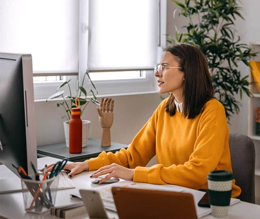 A woman reads about a zero-day exploit on her computer.