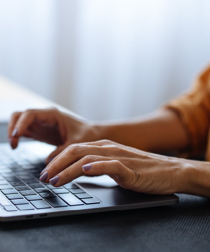 Photo of someone typing on a laptop.