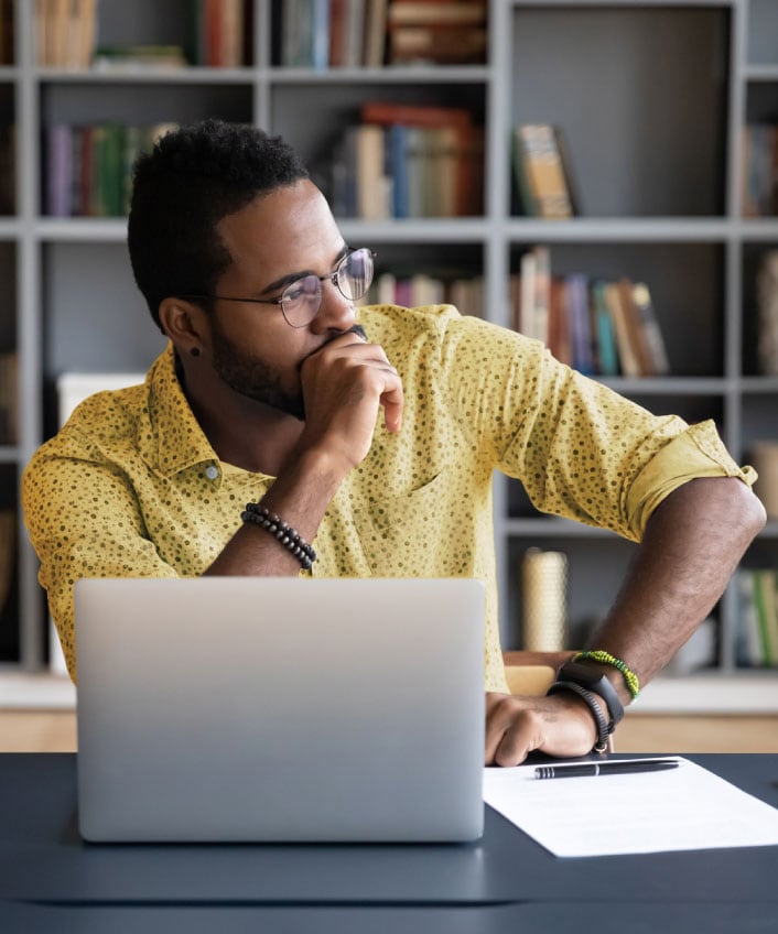 A man contemplates cloud security risks while using his laptop. 