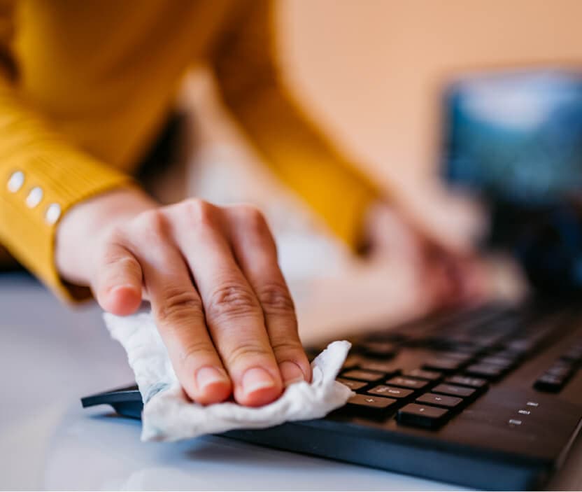 A person protecting their device by following essential computer maintenance tips.