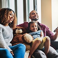 A family watching their smart TV, but aware of the potential privacy risks associated with it.