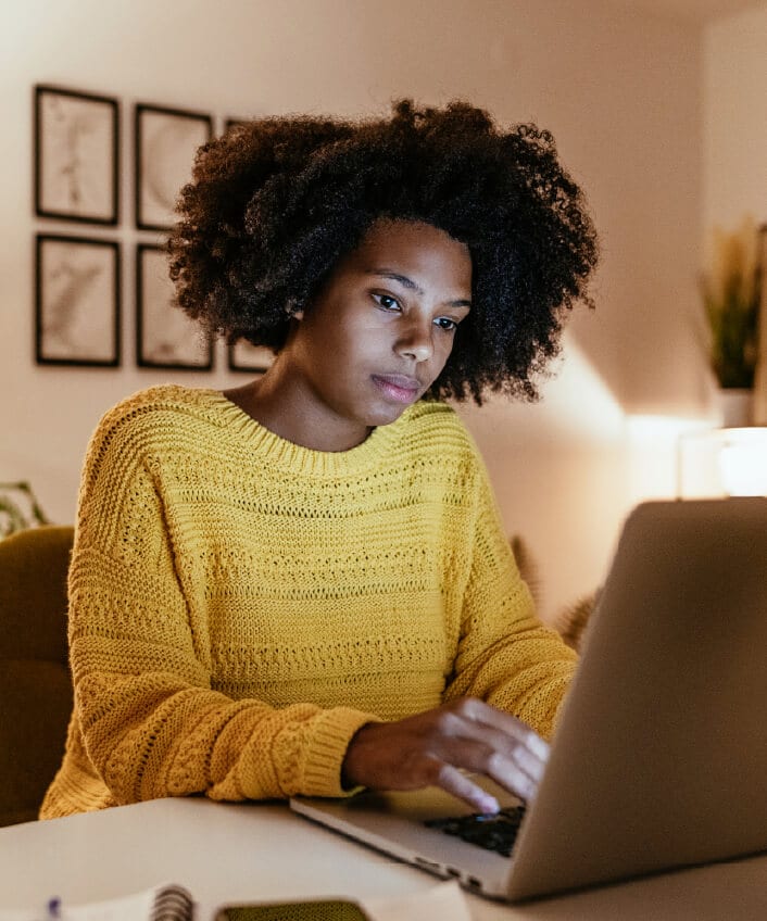 A woman looks at a message on her computer that could be a Google Chat scam.