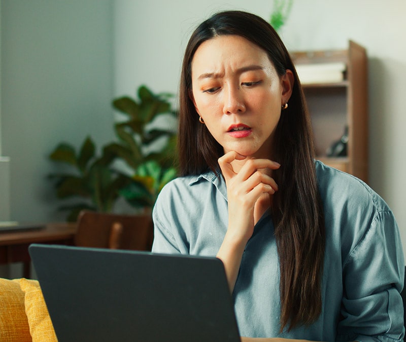 A woman wondering if her computer has experienced hard drive failure.