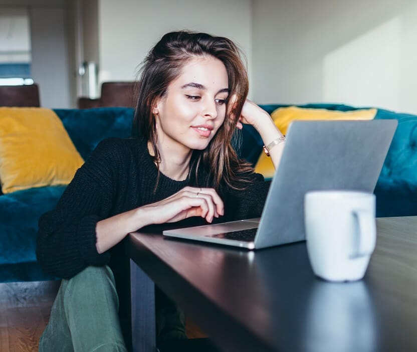 A woman sitting at a coffee table learning how to encrypt email.