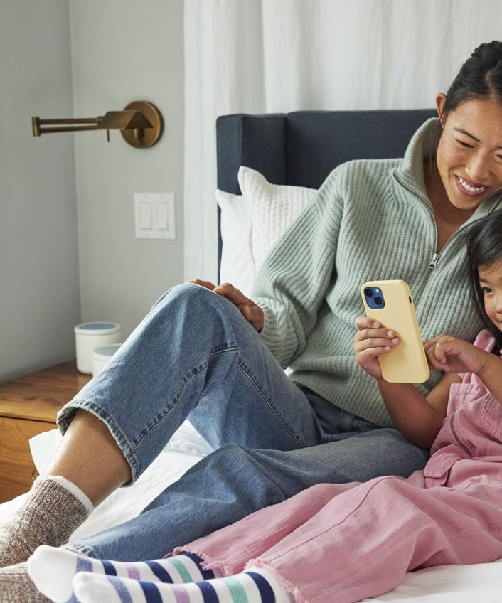 A mother and daughter browsing a device that is protected from malware like computer worms.