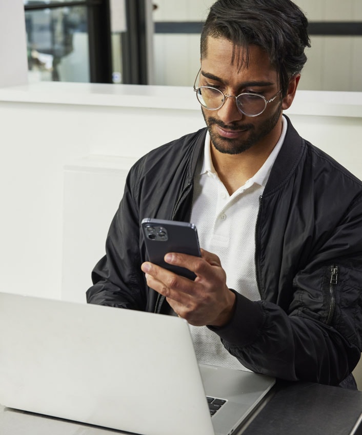 Man in glasses and jacket performing a social media cleanup for improved cybersecurity.