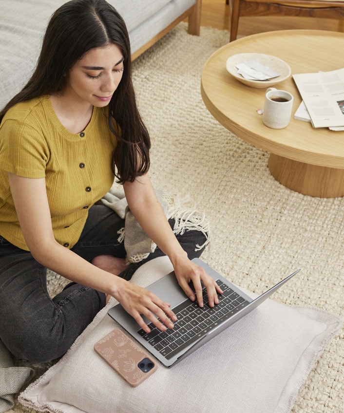 A woman using laptop to research ways to protect her smart speaker from hackers.