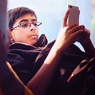 Two children looking intensely at their mobile devices.