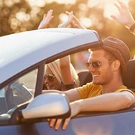 People in a rental car using the infotainment system, illustrating the importance of data security.