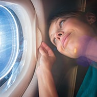 Woman bored on airplane wondering if it's safe to connect to the plane Wi-Fi.