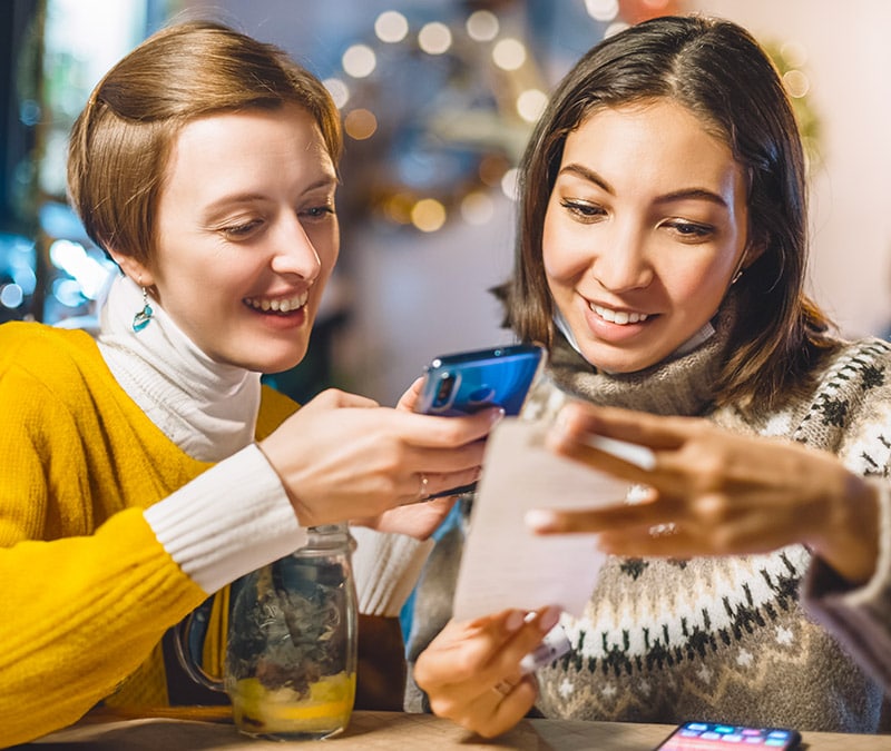 Two women engrossed in their phones.