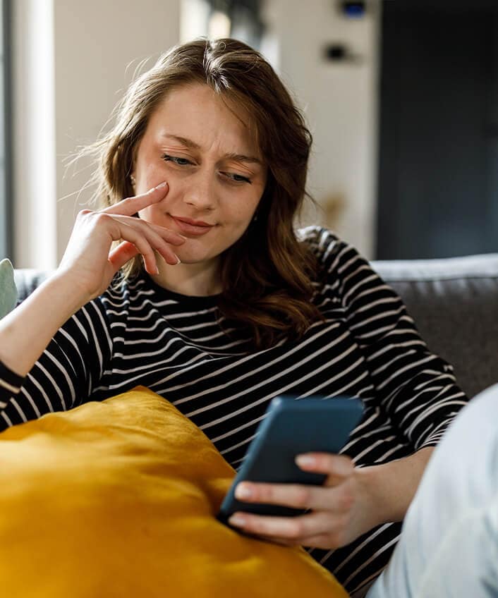 A woman takes a closer look at a possible vishing scam on her phone.