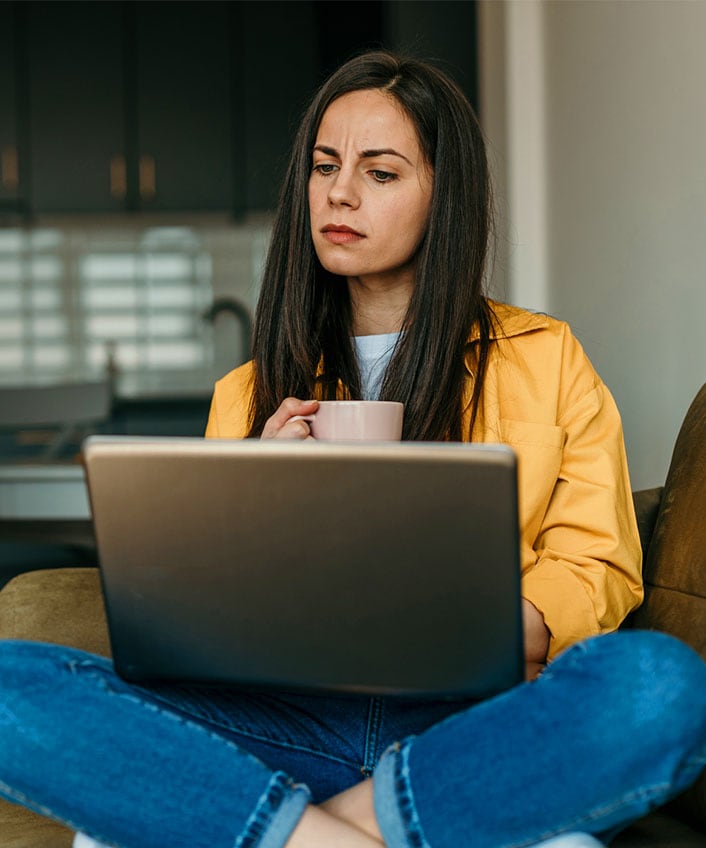 Woman looking at her computer learning about cyberstalking.