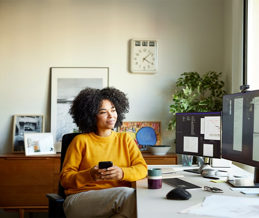 Woman sits at her computer staying vigilant against sophisticated scams, which data shows they are growing in significance. 