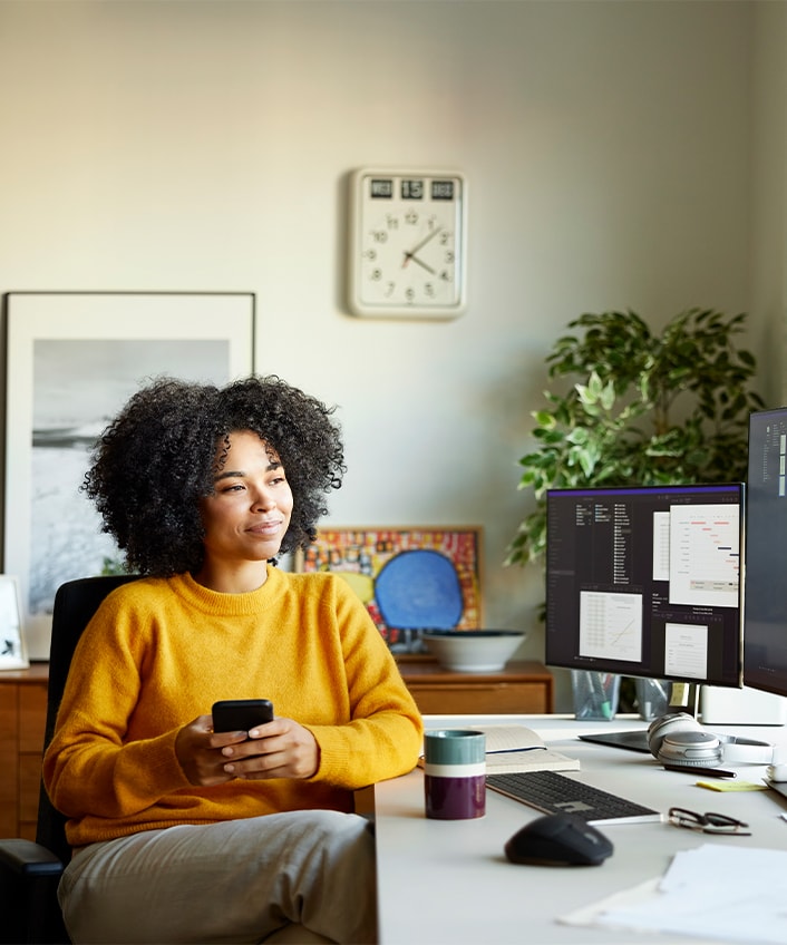 Woman sits at her computer staying vigilant against sophisticated scams, which data shows they are growing in significance. 